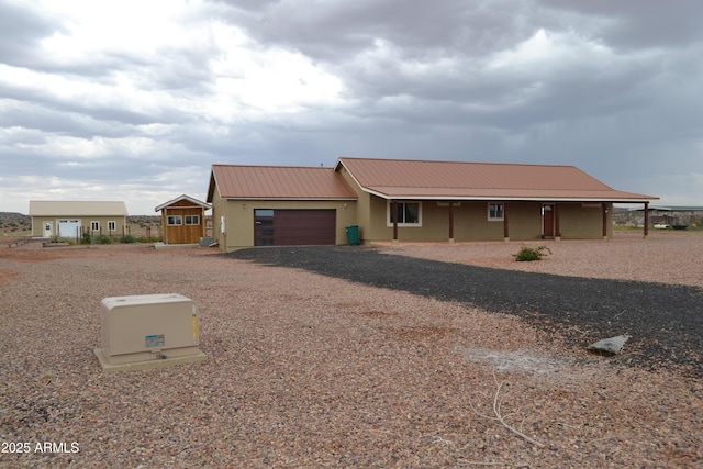 2740 E Walnut Dr, Show Low, AZ 85901 - view of front of house featuring a garage, dirt driveway, metal roof, and stucco siding
