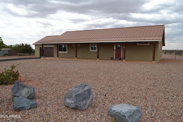 2740 E Walnut Dr, Show Low, AZ 85901 - view of front facade featuring a garage, metal roof, stucco siding, and gravel driveway