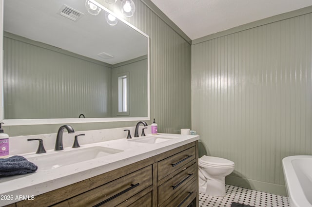 bathroom with vanity, a tub, and toilet