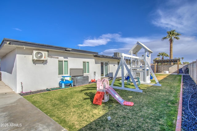 back of property with a pergola, ac unit, a lawn, and a playground