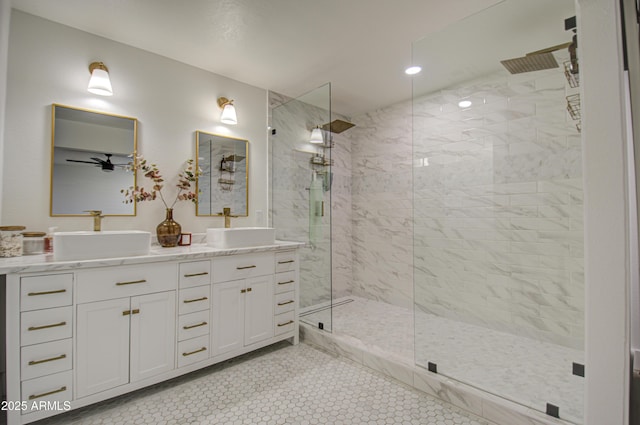 bathroom with tile patterned flooring, vanity, a tile shower, and ceiling fan