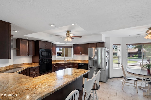 10532 W Catalina Dr, Avondale, AZ 85392 - kitchen featuring black appliances, a ceiling fan, a sink, a peninsula, and light stone countertops