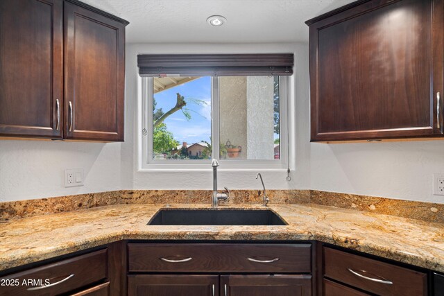 10532 W Catalina Dr, Avondale, AZ 85392 - kitchen with a sink, dark brown cabinetry, and light stone counters