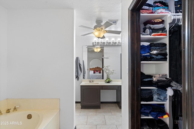 10532 W Catalina Dr, Avondale, AZ 85392 - full bathroom featuring tile patterned flooring, a spacious closet, vanity, a ceiling fan, and a garden tub