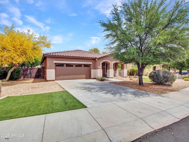 mediterranean / spanish-style house featuring driveway, stucco siding, a tile roof, and a garage