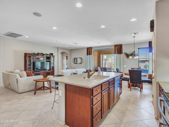 kitchen with dishwasher, visible vents, a sink, open floor plan, and arched walkways
