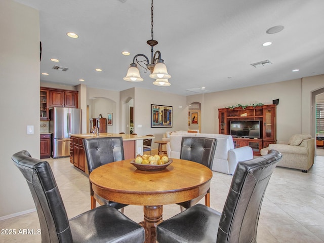 dining room featuring light tile patterned floors, visible vents, arched walkways, a chandelier, and recessed lighting