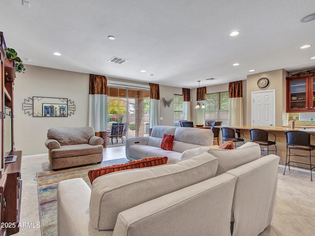 living area featuring light tile patterned floors, visible vents, and recessed lighting