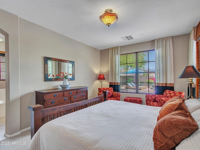 bedroom with visible vents, baseboards, arched walkways, and carpet floors