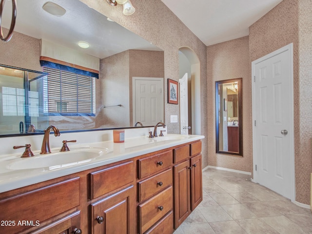 full bathroom with a sink, double vanity, and tile patterned floors