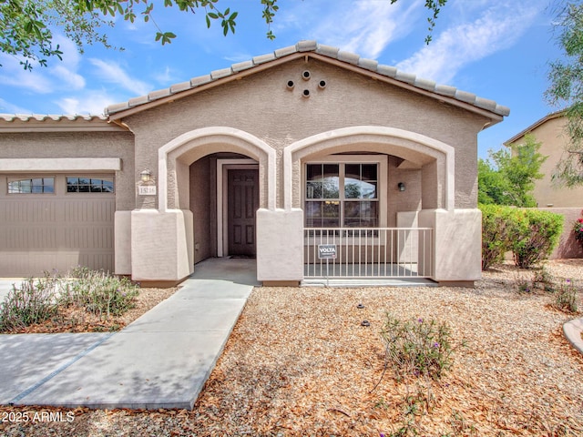 view of front of home with an attached garage, stucco siding, and a porch