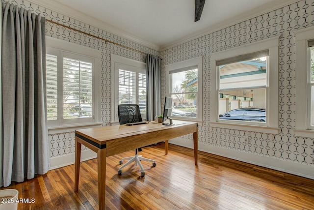 office area with wallpapered walls, crown molding, wood finished floors, and baseboards