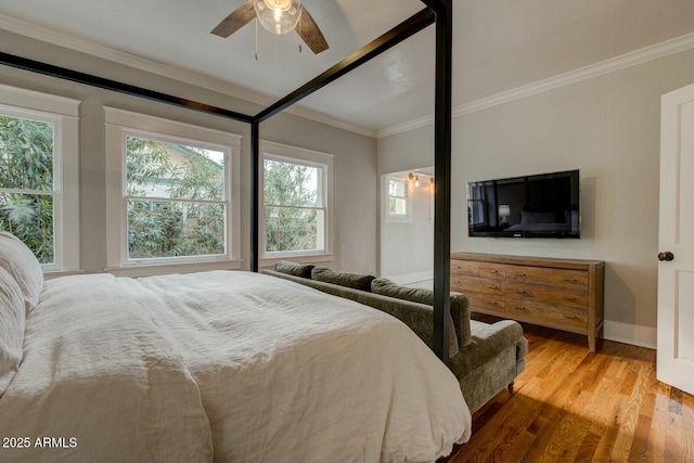 bedroom featuring wood finished floors, baseboards, and ornamental molding