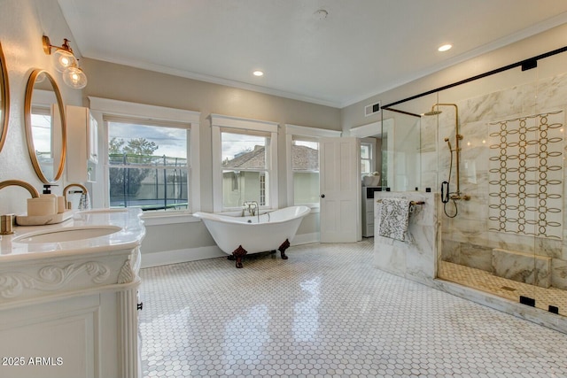 bathroom featuring crown molding, baseboards, a stall shower, a freestanding tub, and vanity