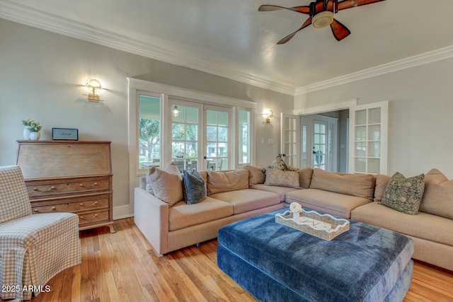 living room with french doors, a ceiling fan, crown molding, and light wood finished floors