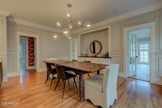 dining area featuring ornamental molding and a decorative wall