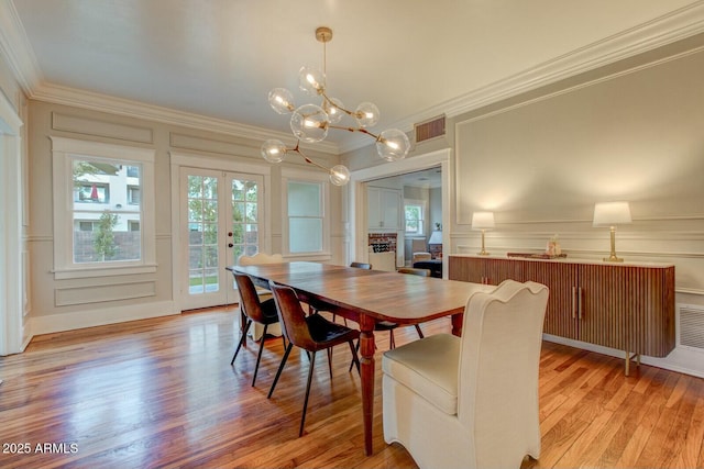 dining space with visible vents, crown molding, and a decorative wall