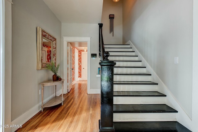 stairs featuring wood finished floors and baseboards