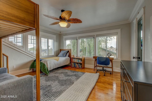 bedroom featuring light wood-style flooring, multiple windows, crown molding, and baseboards