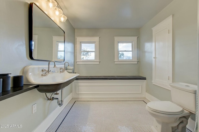 bathroom with tile patterned floors, toilet, and a sink