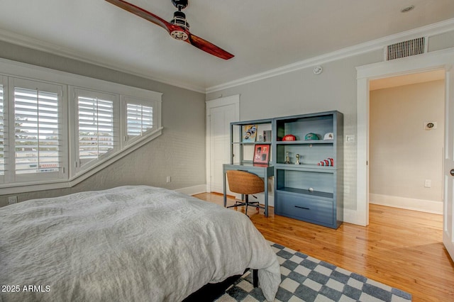 bedroom with baseboards, a ceiling fan, wood finished floors, and crown molding