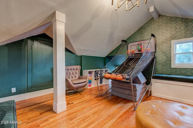 interior space featuring a textured ceiling, vaulted ceiling with beams, and wood finished floors