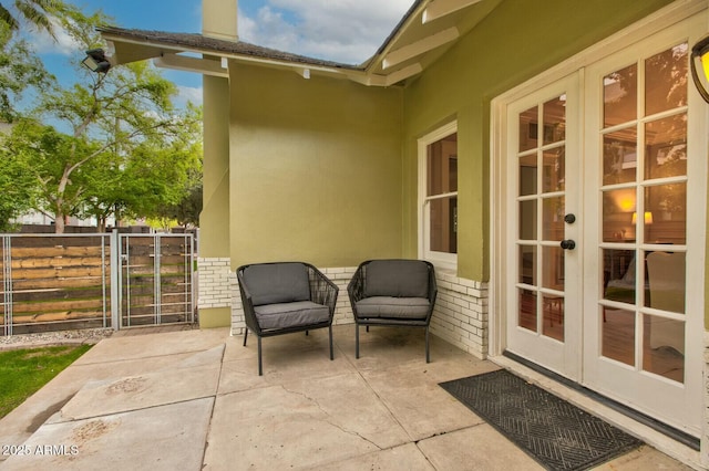 view of patio featuring french doors and fence