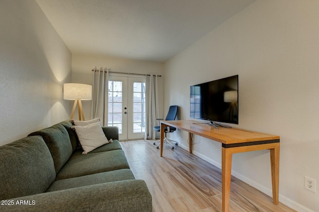 living area with french doors, baseboards, and wood finished floors