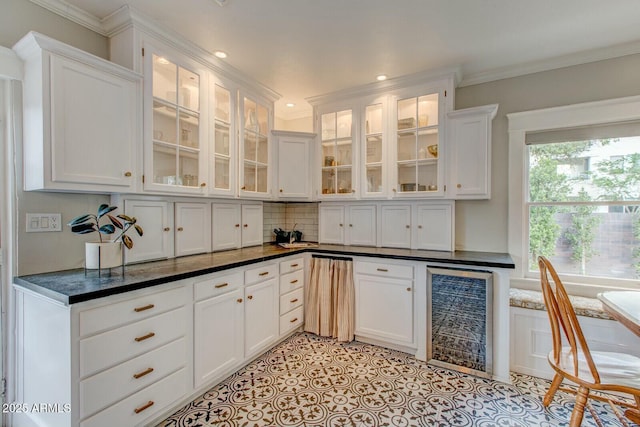 kitchen featuring tasteful backsplash, crown molding, glass insert cabinets, beverage cooler, and white cabinets