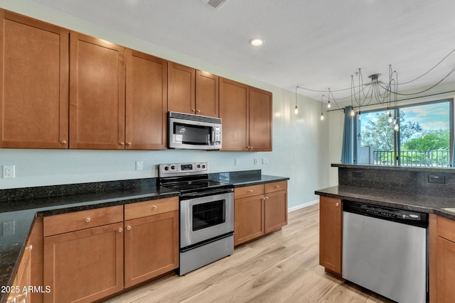 kitchen with brown cabinetry, recessed lighting, light wood finished floors, and stainless steel appliances
