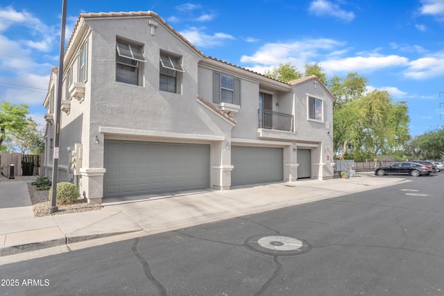 view of front of property with fence, an attached garage, concrete driveway, and stucco siding