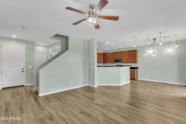 unfurnished living room with baseboards, stairway, recessed lighting, a ceiling fan, and light wood finished floors