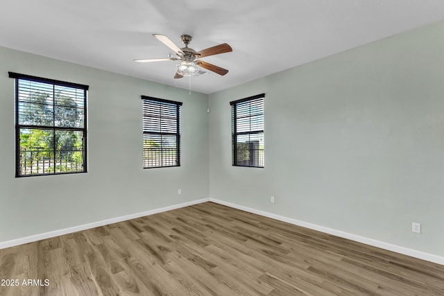 unfurnished room with baseboards, a ceiling fan, and wood finished floors