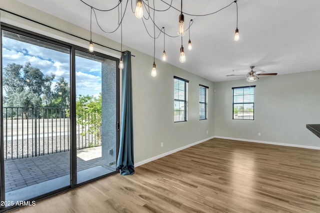 interior space featuring baseboards, ceiling fan, and wood finished floors