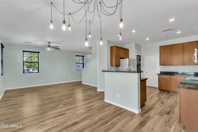 kitchen featuring stainless steel fridge, plenty of natural light, light wood-style floors, and recessed lighting