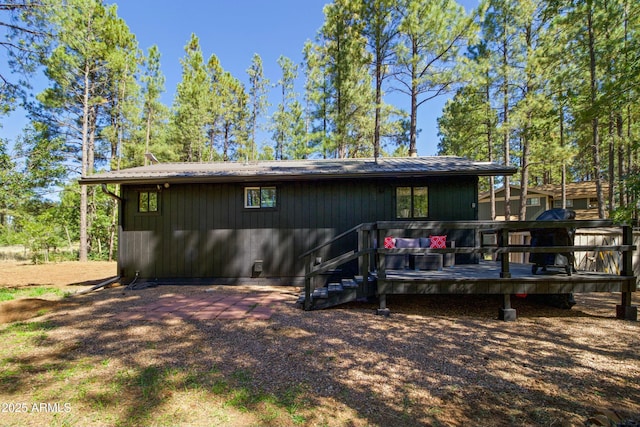 back of property with a wooden deck and metal roof
