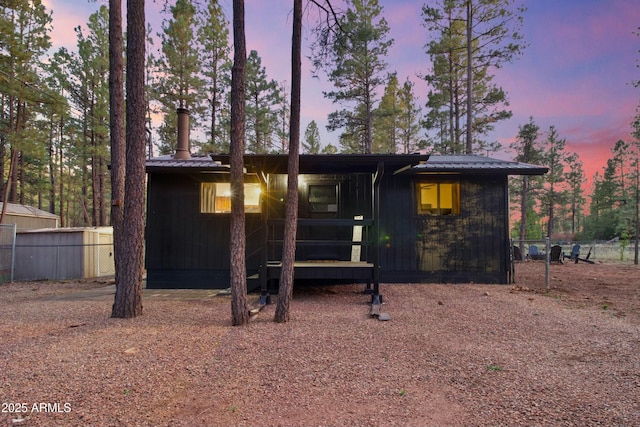 view of front of house featuring fence and metal roof