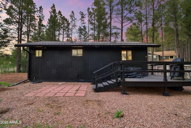 back of house featuring a wooden deck and metal roof