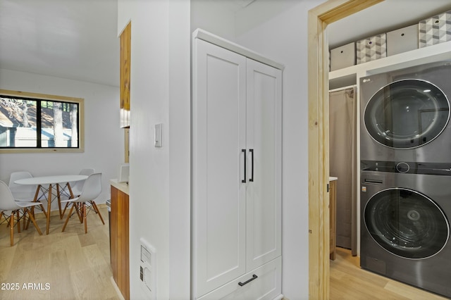 washroom featuring stacked washer and dryer, laundry area, visible vents, and light wood finished floors
