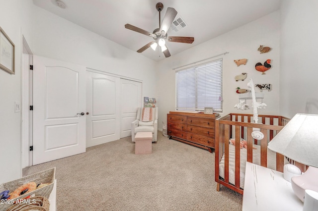 carpeted bedroom featuring ceiling fan, visible vents, and a closet