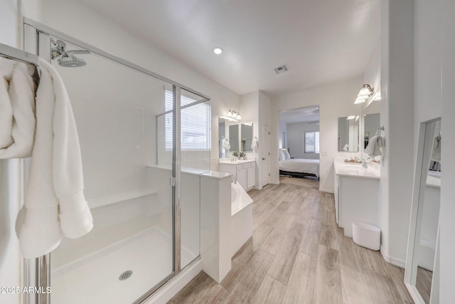 bathroom with visible vents, vanity, wood finished floors, connected bathroom, and a shower stall