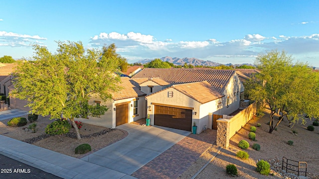 view of front of house featuring a tiled roof, fence, concrete driveway, an attached garage, and stucco siding