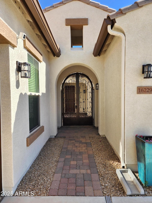 view of exterior entry with french doors and stucco siding