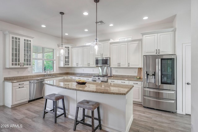 kitchen featuring white cabinets, stainless steel appliances, and visible vents