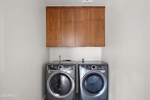 washroom featuring cabinets and washing machine and dryer