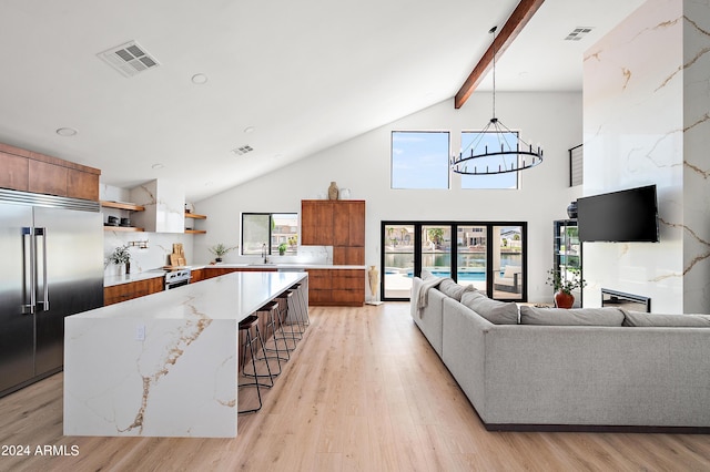 living room featuring beamed ceiling, sink, high vaulted ceiling, an inviting chandelier, and light hardwood / wood-style floors