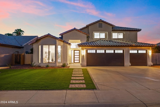 mediterranean / spanish house with a garage and a yard