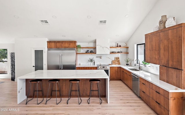 kitchen with stainless steel appliances, a center island, sink, and a healthy amount of sunlight