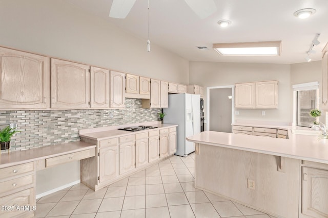 kitchen with light tile patterned floors, visible vents, lofted ceiling, light countertops, and white fridge with ice dispenser