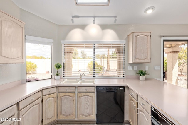 kitchen featuring dishwasher, light countertops, light brown cabinets, and a sink